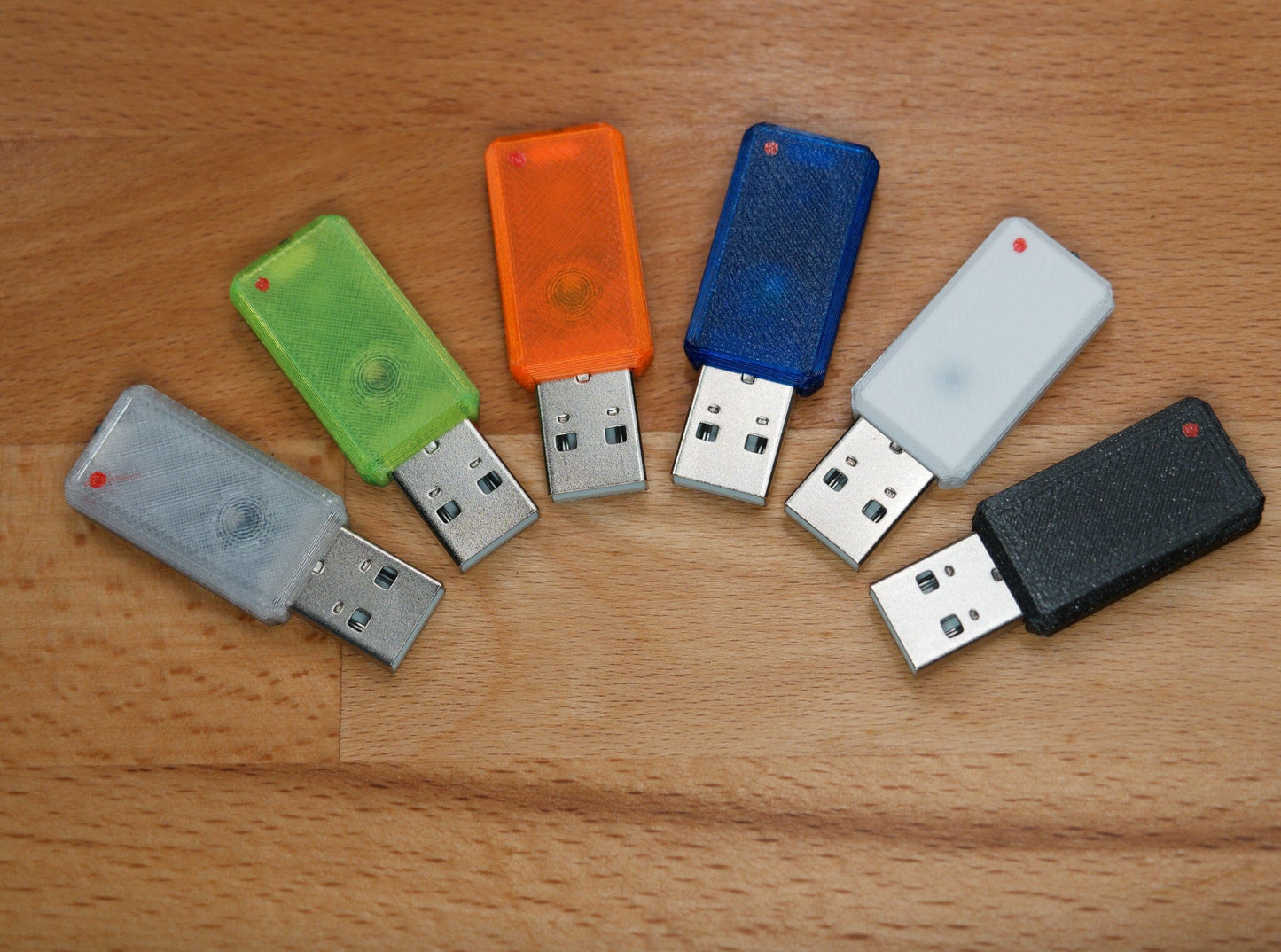 6 USB Novas with different colored cases. In transparent, green, orange, blue, white, black.