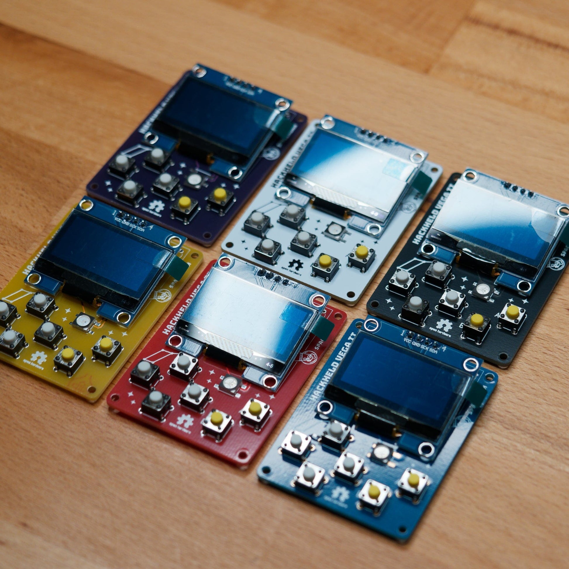 HackHeld Vega II PCBs in purple, white, black, yellow, red, blue with components