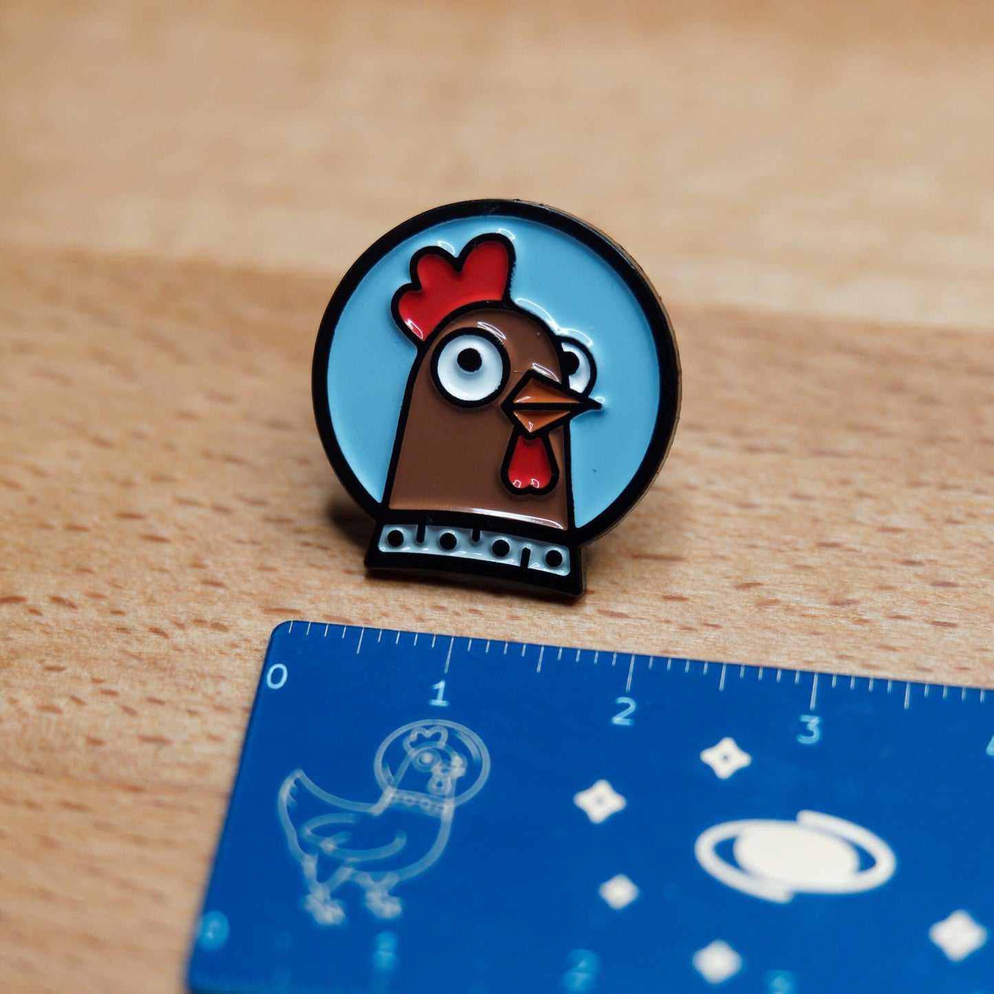 Spacehuhn Enamel Pin with ruler showing it's 22mm wide